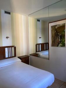 a bedroom with two beds and a mirror at Apartamentos de Astroturismo la Cañada in Torrejón el Rubio