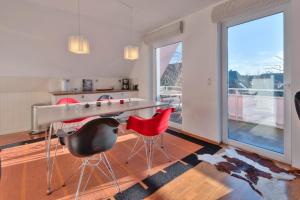 une cuisine avec une table et deux chaises rouges dans l'établissement "Schwedenhaus" Das Schwedenhaus, Whg Karlsson, à Büsum