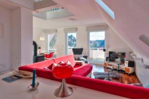 - un salon avec un canapé rouge et une cheminée dans l'établissement "Schwedenhaus" Das Schwedenhaus, Whg Karlsson, à Büsum