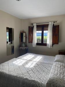a bedroom with a large white bed with a window at Apartamentos de Astroturismo la Cañada in Torrejón el Rubio