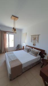 a bedroom with a large bed in a room at Sarakiniko Rooms in Adamantas