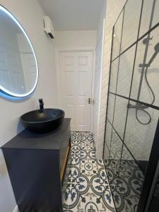 a bathroom with a black sink and a mirror at Two bedroom townhouse in the heart of Dungarvan in Dungarvan