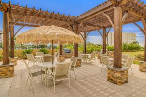 a patio with a table and chairs under a pergola at Luau #6633 in Destin