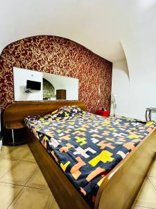 a bedroom with a bed with a colorful comforter at Lemberg Elite Apartments in Lviv