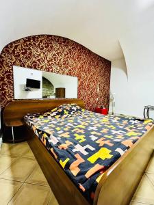 1 dormitorio con 1 cama con un edredón colorido en Lemberg Elite Apartments, en Leópolis