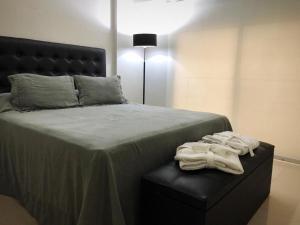 1 dormitorio con 1 cama con silla y toallas en san telmo sos hermoso en Buenos Aires