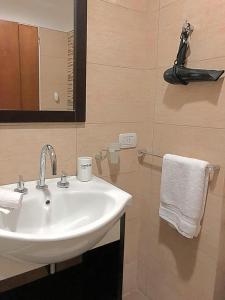 y baño con lavabo, espejo y toalla. en san telmo sos hermoso en Buenos Aires