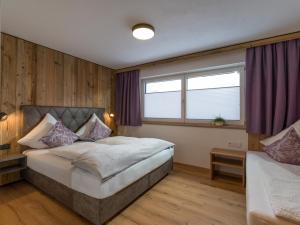 um quarto com uma cama grande e uma janela em Alps Holaus em Aschau