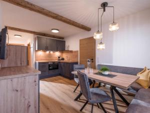 a kitchen and living room with a table and chairs at Alps Holaus in Aschau