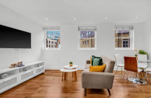 een woonkamer met een tv en een bank en een tafel bij Two Bedroom Serviced Apartment in Artillery Lane in Londen