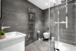 a bathroom with a shower and a toilet and a sink at Two Bedroom Serviced Apartment in Artillery Lane in London
