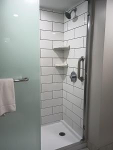 a bathroom with a shower with a glass door at Quality Inn & Suites Oceanfront in Virginia Beach