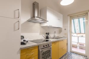 una cocina con armarios amarillos y fregadero en A Casa di Zia Vaticano, en Roma