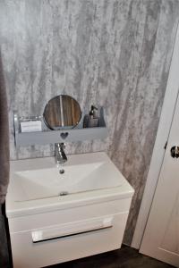 a bathroom with a white sink and a mirror at The Windy Roost in Occumster