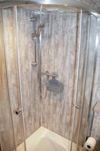 a shower with a glass door in a bathroom at The Windy Roost in Occumster