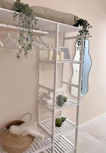 a white shelving unit in a room with plants at Fiera Milano City Apartment in Milan
