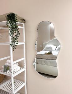 a mirror hanging on a wall next to a bed at Fiera Milano City Apartment in Milan