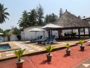 ein Resort mit einem Pool, Stühlen und Sonnenschirmen in der Unterkunft Hotel La Madrague in Grand-Bassam