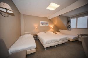 een kamer met 2 bedden en een raam bij Hotel Louisa in Oostende