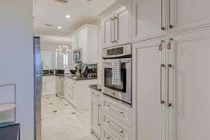 a kitchen with white cabinets and a stove top oven at Highland Beach Palace in Highland Beach