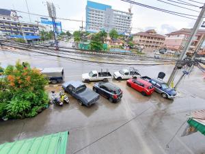 Phakdee Place في تشانتابوري: مجموعة من السيارات تقف في موقف للسيارات