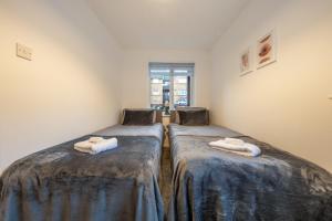 two twin beds in a room with two towels at Luxury 2 Bed Apartment Stansted Airport Bishops Stortford in Bishops Stortford