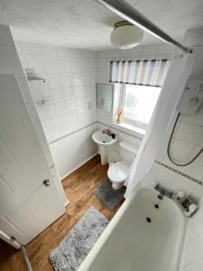a bathroom with a tub and a toilet and a sink at Luxury 2 Bed Apartment Stansted Airport Bishops Stortford in Bishops Stortford