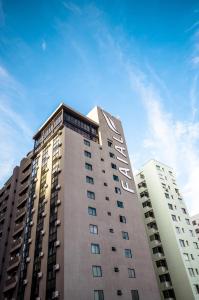 un edificio alto con las palabras hotel en él en Faial Prime Suítes, en Florianópolis