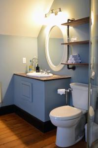 a bathroom with a toilet and a sink with a mirror at Magnetic Hill Winery in Moncton