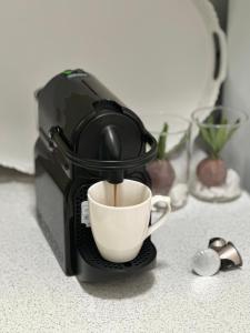 een koffiezetapparaat is het maken van een kopje koffie bij Magnolia - Apartment in Kalamata in Kalamata