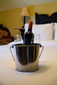 a bottle of wine and two glasses in a bucket on a bed at Magnetic Hill Winery in Moncton