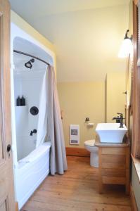 a bathroom with a tub and a sink and a toilet at Magnetic Hill Winery in Moncton
