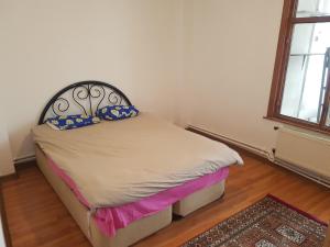 um pequeno quarto com uma cama com uma cabeceira preta em Просторная квартира 2 plus 1 с панорамным видом на море em Darıca