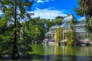 a conservatory in a park with a lake and trees at Home Art Apartments Salamanca in Madrid