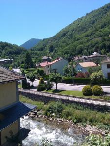 a town with a river and houses and a mountain at Appartement FARIO in Ax-les-Thermes