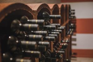 una fila de botellas de vino en un estante de vinos en Villa Vinory Bricco di Nizza, en Nizza Monferrato