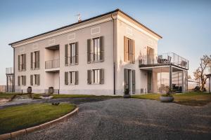 Großes weißes Gebäude mit Balkon in der Unterkunft Villa Vinory Bricco di Nizza in Nizza Monferrato