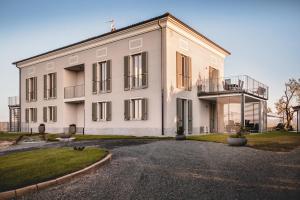 a large white building with a balcony at Villa Vinory Bricco di Nizza in Nizza Monferrato