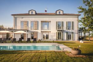 una casa grande con piscina frente a ella en Villa Vinory Bricco di Nizza, en Nizza Monferrato