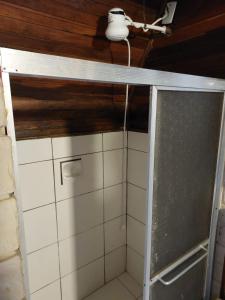 a shower in a bathroom with white tiles at HOTEL LAS CABANAS in São Gabriel