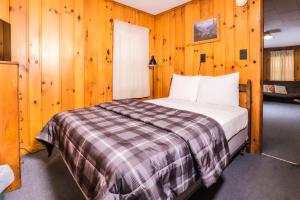 a bedroom with a bed in a room with wooden walls at Fishing Paradise in Phelps