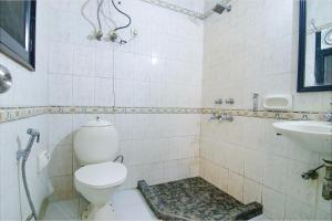 La salle de bains est pourvue de toilettes et d'un lavabo. dans l'établissement FabHotel Singh Suite, à Gurgaon