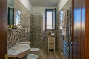 Un baño con lavabo, inodoro y ducha. en La terrazza di Zoe - Castromediano ( Lecce), en Cavallino di Lecce