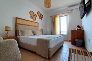 - une chambre avec un grand lit et une fenêtre dans l'établissement Sarakiniko Rooms, à Adamas