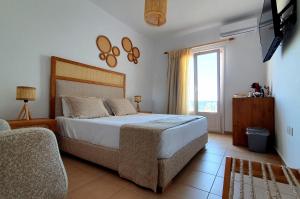 a bedroom with a large bed and a window at Sarakiniko Rooms in Adamas