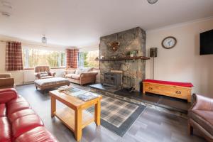 a living room with a fireplace and a couch at Silverbridge Lodge in Garve