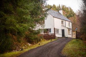 a white house on the side of a road at Silverbridge Lodge in Garve