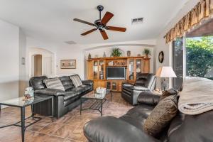 a living room with leather furniture and a flat screen tv at Honeysuckle Hideaway in Gold Canyon