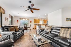 a living room with leather furniture and a ceiling fan at Honeysuckle Hideaway in Gold Canyon