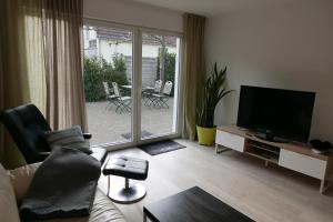 Grasshoppers في موسينغن: غرفة معيشة بها أريكة وتلفزيون